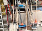 a pile of brooms and other tools in a garage