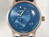 a close up of a wrist watch with a blue dial