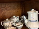 une étagère en bois sur laquelle sont posées une théière et des tasses