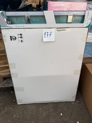 un réfrigérateur posé au milieu d'une pile de cartons