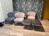 trois chaises et une table dans une pièce dont l'un des murs est tapissé