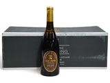 une bouteille de vin posée à côté d'un carton de vin sur une surface blanche