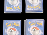four pokemon cards are in a clear plastic case on a black background