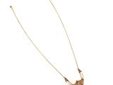 the gold necklace is adorned with a long chain with a bird on it