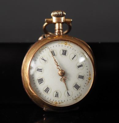 a gold pocket watch with roman numerals on the face