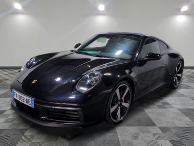 une photo d'une voiture de sport noire posée sur un sol à damier