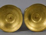 a pair of brass candlesticks in the shape of a spiral