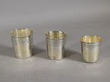 three silver cups sitting on top of a table next to each other