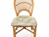 the back of a bamboo chair with a green and white cushion