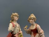 paire de figurines en porcelaine représentant une femme et un homme tenant des fleurs