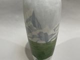 a white vase with a green and white design on it