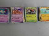 plusieurs cartes de pokémon sont alignées sur une surface blanche