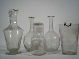 trois vases en verre et un verre posés sur une table