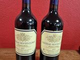 deux bouteilles de vin posées sur une table en bois, près d'un mur rouge