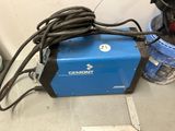 une soudeuse électrique posée sur un comptoir, à côté d'une règle graduée