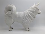 a statue of a dog that is standing on a white surface