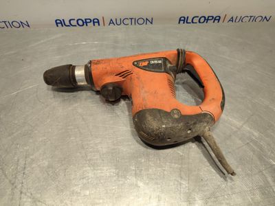 un gros plan d'une perceuse orange sur une surface métallique