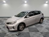 La Toyota Corolla est garée dans une pièce dont le sol est en damier.