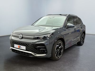 un SUV Volkswagen gris garé dans une pièce au sol noir