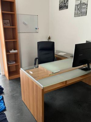 a desk with a computer and a monitor in a room