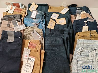plusieurs paires de jeans sont disposées sur une table