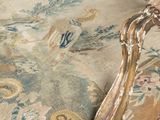 a close up of a chair that has a tapestry on it
