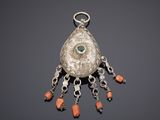 une image représentant un pendentif en argent orné de perles de corail et d'un œil