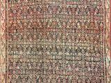 an antique persian rug with a red border and a floral design