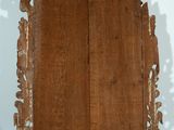 a wooden frame with carvings on it on a black surface