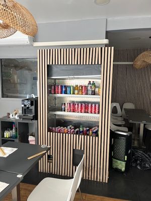 a room with a table, chairs, and a refrigerator in it
