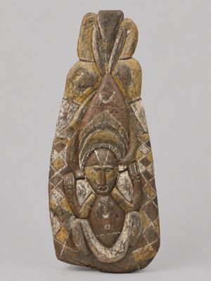 une sculpture marron et blanche représentant une femme tenant un enfant dans ses bras