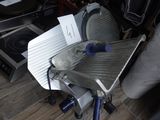 une grande trancheuse posée sur une table en métal