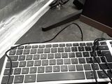 a computer keyboard and a cell phone sitting on a desk
