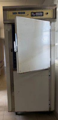 un réfrigérateur qui se trouve dans le coin d'une pièce