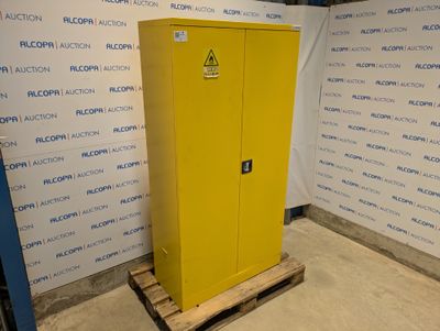 une photo d'une armoire jaune dans une pièce, avec une affiche accrochée au mur derrière elle