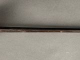 a sword with a gold handle on a white surface