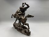 a bronze statue of a man riding a horse on a rock