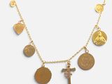 a close up of a gold necklace with various charms on it