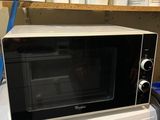 un micro-ondes posé sur une machine à laver et un sèche-linge