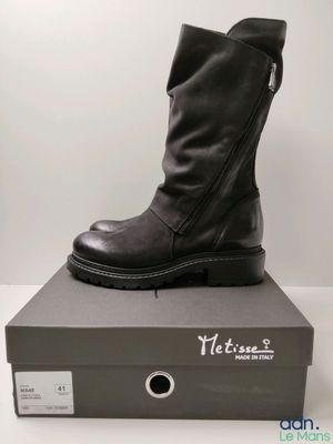 black leather boots with zippers are on top of a box