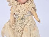 a small doll that is wearing a dress and hat