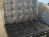 un fauteuil en cuir noir et une chaise noire dans une pièce