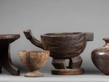 three wooden vases and a bowl are sitting on a table