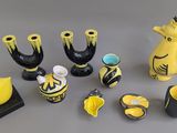 des vases jaunes et noirs ainsi que d'autres objets décoratifs posés sur une surface grise