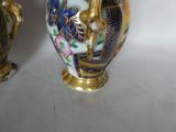 two vases sitting side by side on a white surface