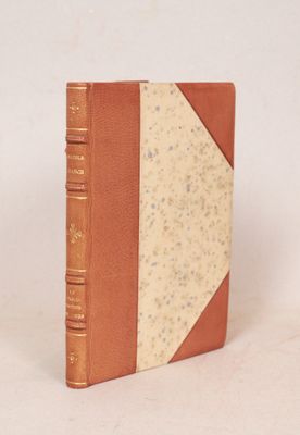 un vieux livre à la couverture brune posé sur une surface blanche