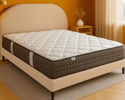 une photo d'un matelas dans une chambre dont le mur est jaune