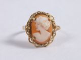 a close up of a gold ring with a cameo of a woman