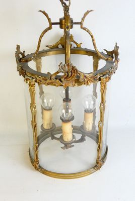 a glass lantern with three candles inside of it