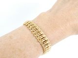 someone is wearing a gold chain bracelet on their arm